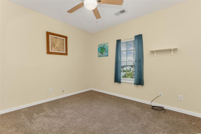Carpeted empty room featuring a ceiling fan and baseboards | Image 12