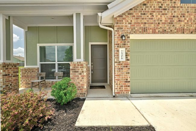 Property entrance with covered porch, a garage, and brick siding | Image 4