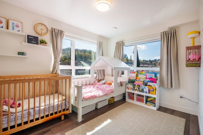 Bedroom with multiple windows and wood finished floors | Image 12