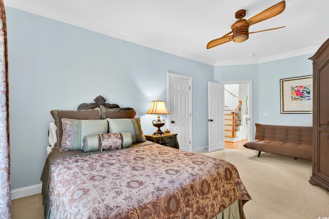 Bedroom with light carpet, crown molding, and a ceiling fan | Image 28