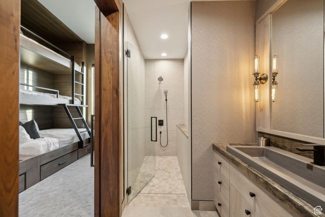 Full bathroom featuring a shower stall, vanity, ensuite bathroom, a textured wall, and recessed lighting | Image 57