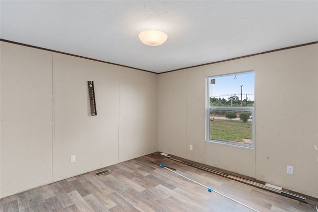 Spare room featuring light wood finished floors and crown molding | Image 25