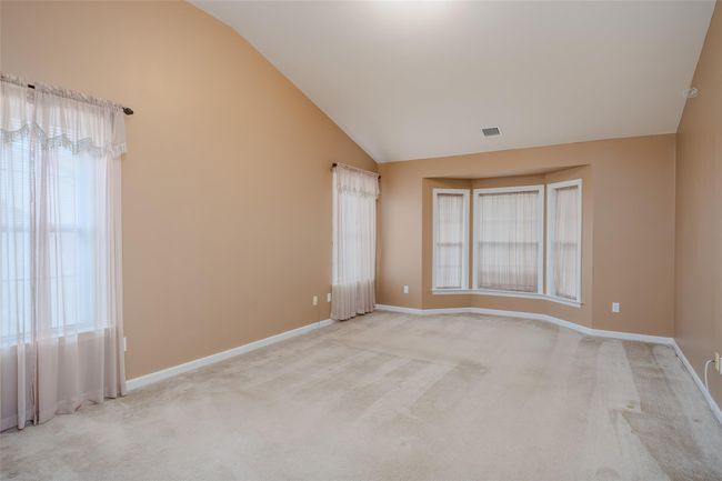Unfurnished room featuring lofted ceiling, healthy amount of natural light, and light carpet | Image 16