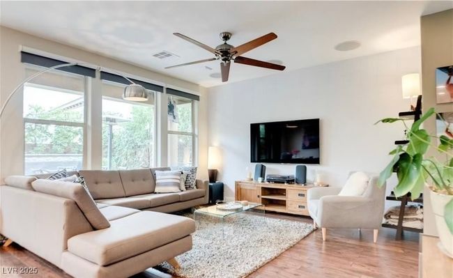 Living area featuring a ceiling fan, visible vents, and wood finished floors | Image 6