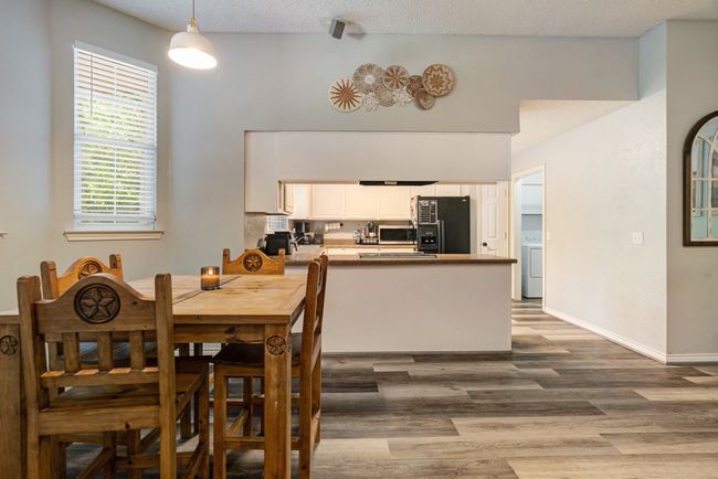 Dining space featuring wood finished floors, washer / clothes dryer, and a textured ceiling | Image 5