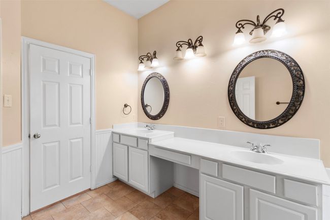 Full bath featuring wainscoting, double vanity, and stone finish flooring | Image 17