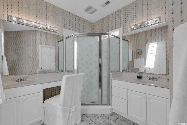 Primary Bathroom featuring wallpapered walls, tile patterned flooring, a stall shower, two vanities, water closet, and main clothes closet | Image 23