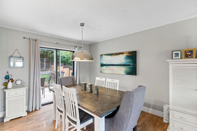 Dining room with ornamental molding, baseboards, light wood-type flooring, and a textured ceiling | Image 12