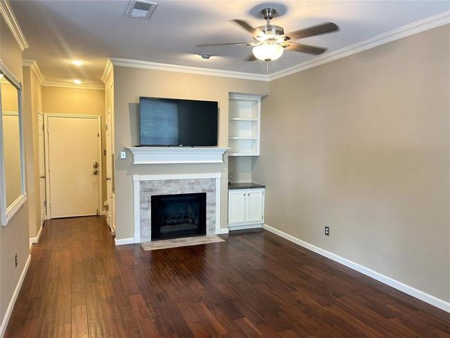 Another view of the den from the front door, the kitchen and laundry are on the left and stairs to upstairs on the right. The covered parking is just outside the door straight ahead. | Image 15