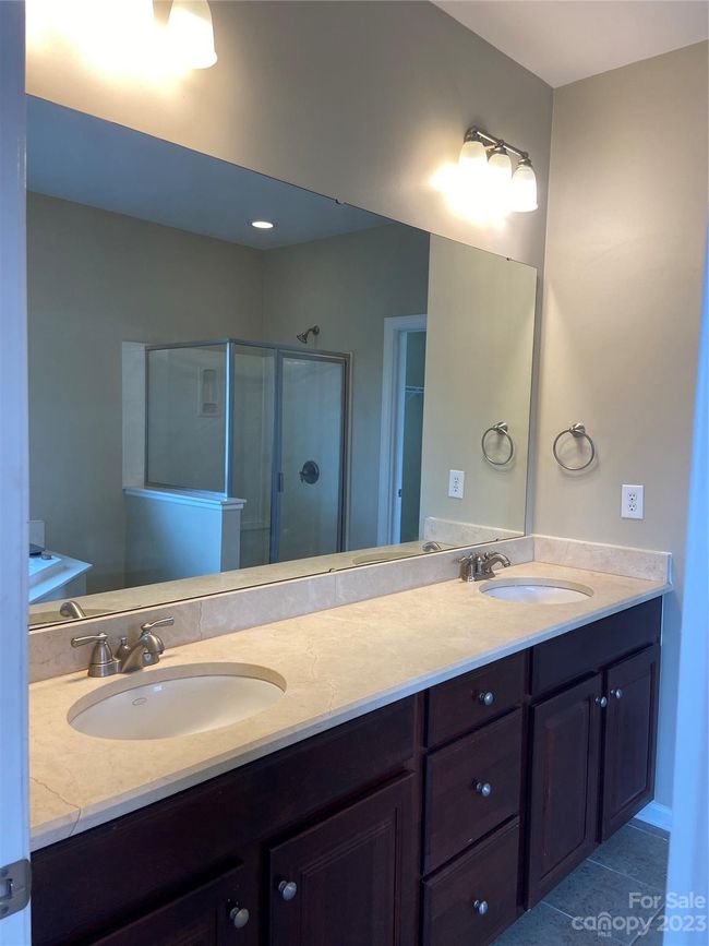 Primary bathroom has dual sinks, garden tub, separate standing shower, and water closet. Closet access is in the bathroom. | Image 17