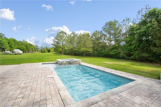 View of pool with a pool with connected hot tub, a yard, and a patio area | Image 22