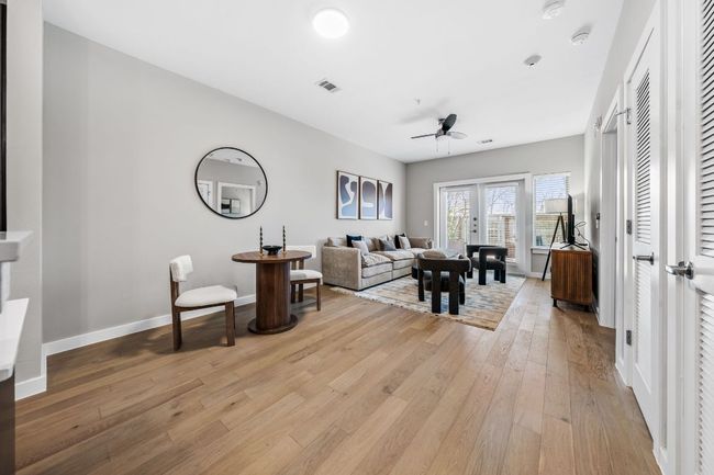 Living area featuring light wood finished floors, visible vents, baseboards, and ceiling fan | Image 12