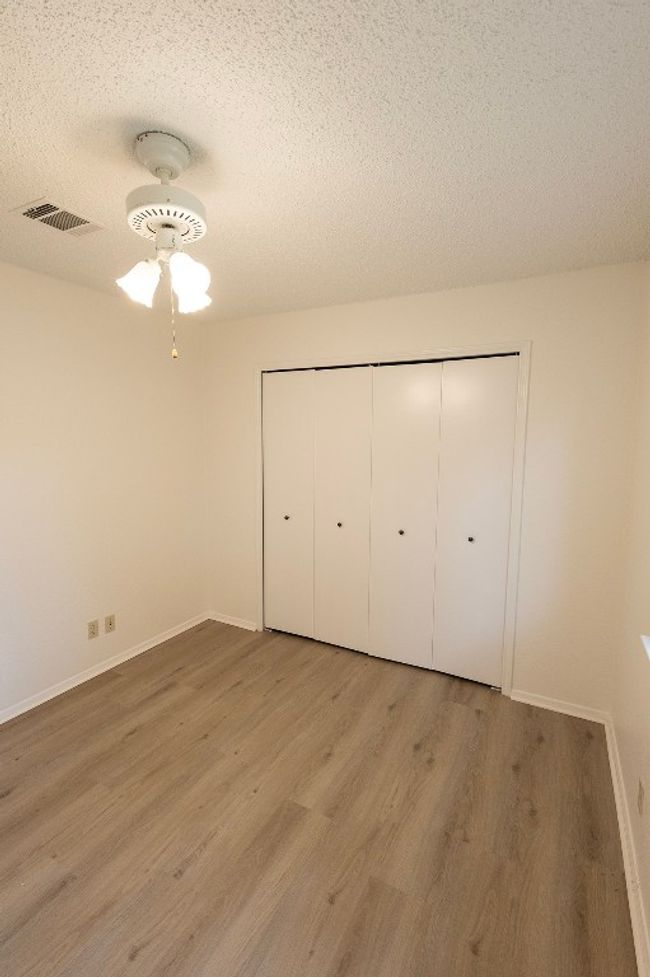 Unfurnished bedroom with a textured ceiling, light wood finished floors, baseboards, and a closet | Image 17