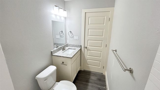 Bathroom with vanity, wood finished floors, and a textured wall | Image 8
