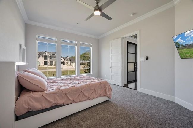 Carpeted bedroom with ornamental molding, baseboards, and a ceiling fan | Image 21