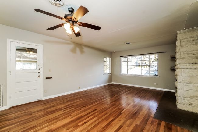 Unfurnished living room with a ceiling fan and wood finished floors | Image 8