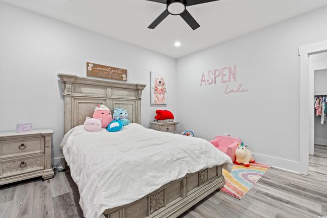 Bedroom with wood finished floors, ceiling fan, and recessed lighting | Image 24