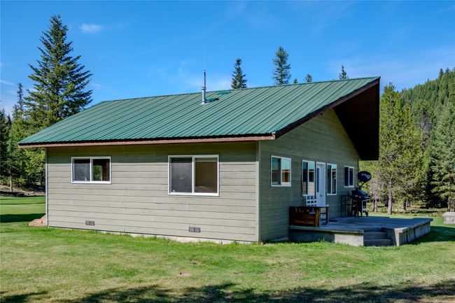 Rear view of house featuring a yard, metal roof, and a deck | Image 74