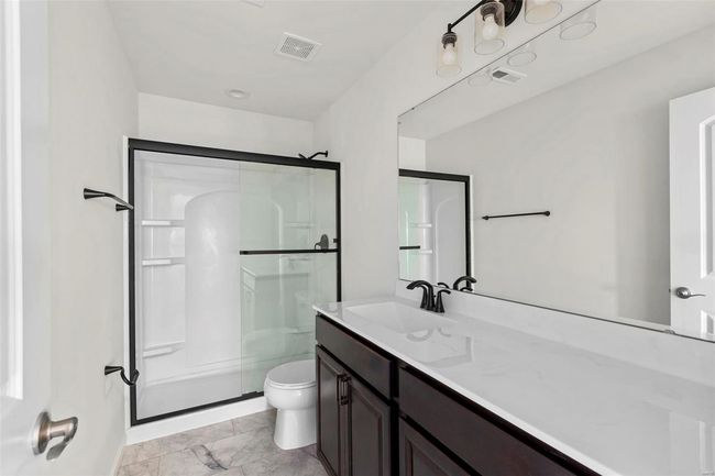 Bathroom featuring toilet, vanity, and walk in shower | Image 9