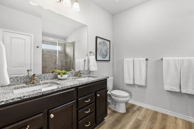 Full bathroom with double vanity, a shower stall, and wood finished floors | Image 25