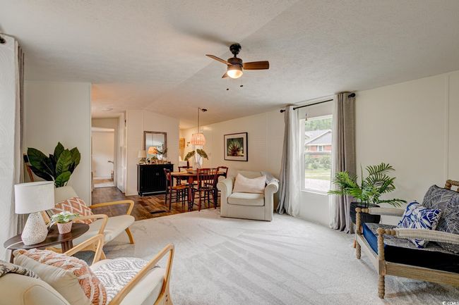 Living area featuring lofted ceiling, a ceiling fan, and a textured ceiling | Image 5
