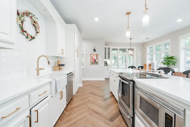 Kitchen with appliances with stainless steel finishes, white cabinets, decorative backsplash | Image 6