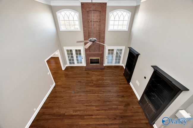 Wood flooring, 18' ceiling, built-in cabinetry, fireplace, double doors open to enclosed back porch | Image 8