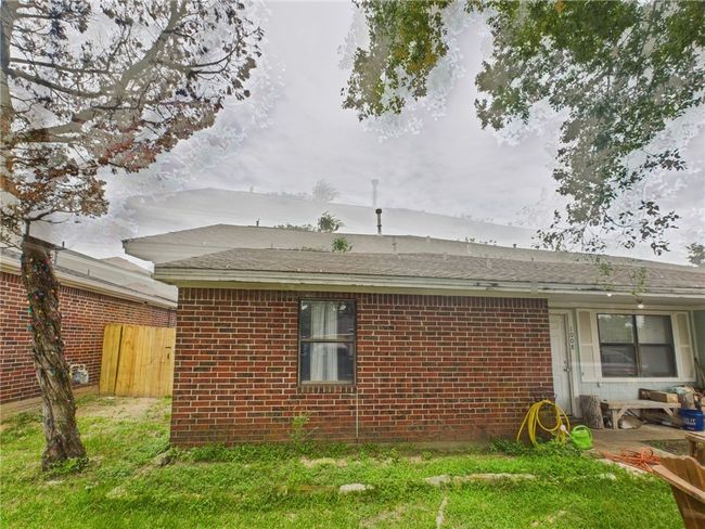 View of home's exterior with brick siding and a shingled roof | Image 14