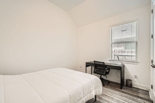 Bedroom with wood finished floors and vaulted ceiling | Image 22