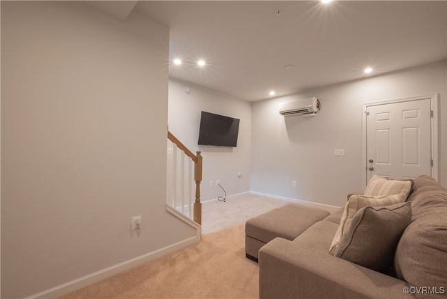 Basement game room with light colored carpet, baseboards, a wall mounted AC, and recessed lighting | Image 29