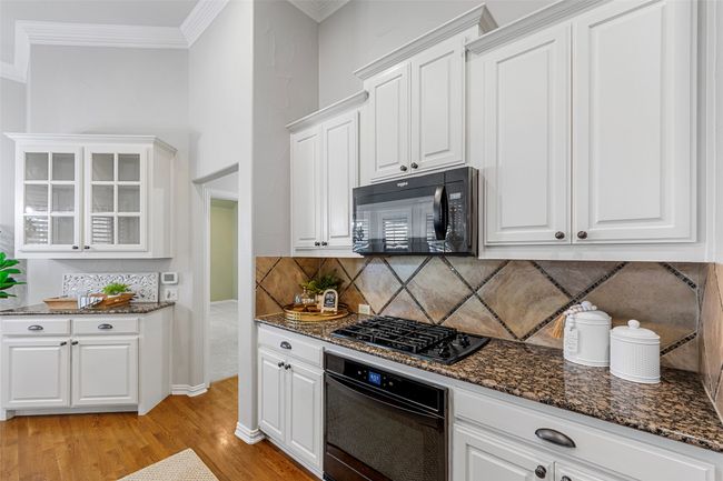 Unfurnished dining area featuring wood finished floors, a chandelier, crown molding, and baseboards | Image 17