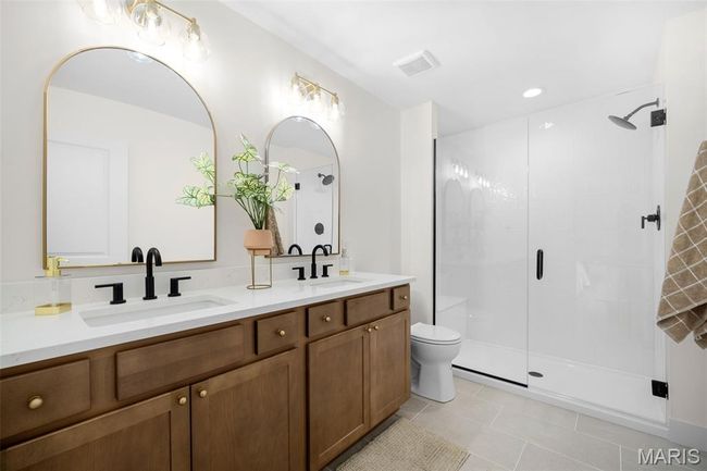 Bathroom with double vanity, a stall shower, tile patterned floors, and recessed lighting | Image 27