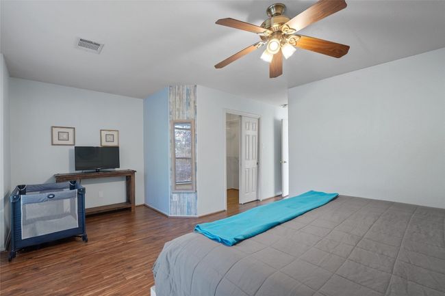 Bedroom with baseboards, visible vents, a ceiling fan, wood finished floors, and a spacious closet | Image 19