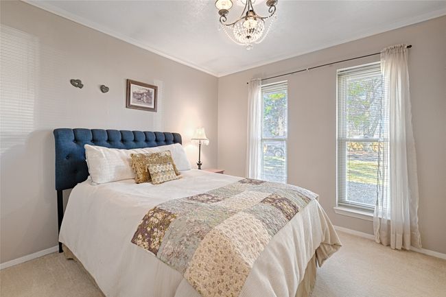 Carpeted bedroom featuring a notable chandelier and crown molding | Image 27