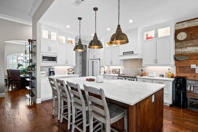 Kitchen with built in microwave, an island with sink, a kitchen bar, decorative backsplash, and recessed lighting | Image 14