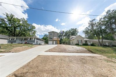 View of front of house featuring a front yard, a garage, and covered porch | Image 1