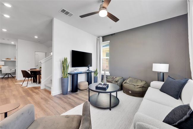 Living area featuring visible vents, ceiling fan, stairway, light wood-type flooring, and recessed lighting | Image 6