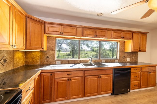 Kitchen with a sink, tasteful backsplash, plenty of natural light, and brown cabinets | Image 11
