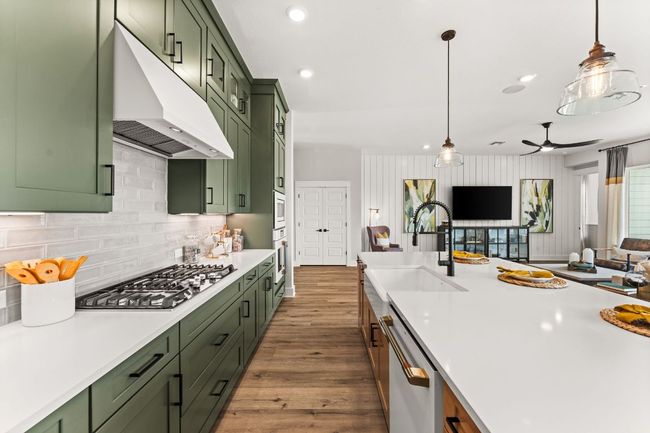 Stunning sage green cabinetry extends to the 10' ceilings, adding dramatic visual appeal and storage. | Image 6