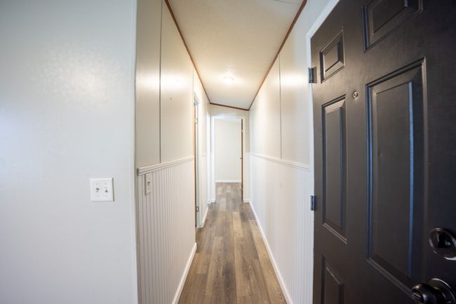 Hallway with wood finished floors, wainscoting, and a decorative wall | Image 9
