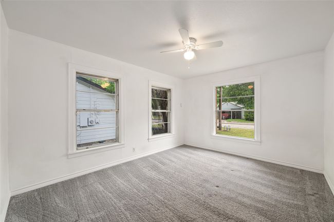 Carpeted empty room featuring plenty of natural light, ceiling fan, and baseboards | Image 16