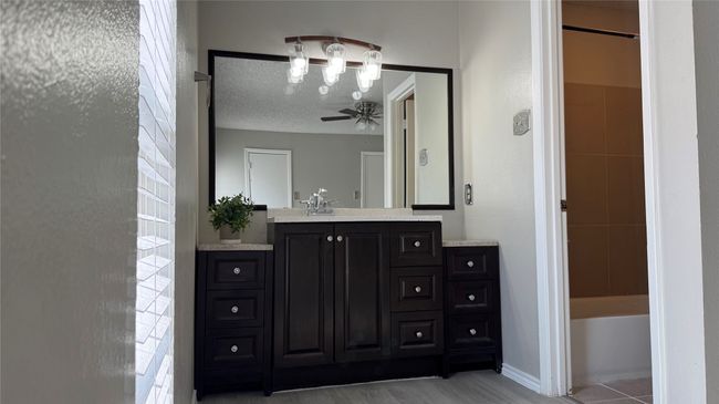 Bathroom featuring vanity, a chandelier, and a ceiling fan | Image 9
