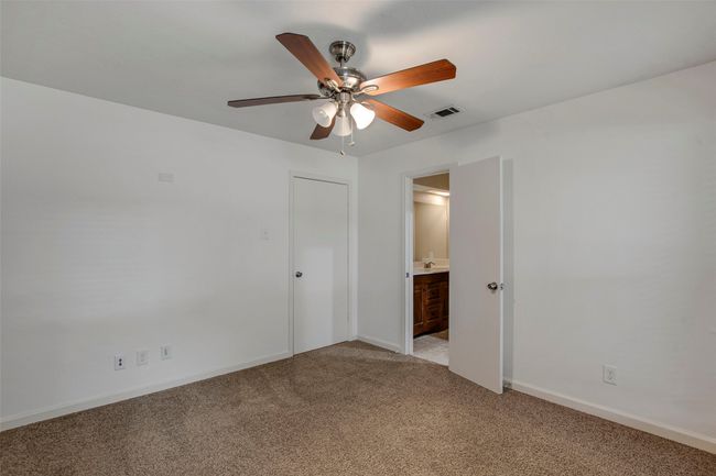 Unfurnished bedroom featuring baseboards, ensuite bathroom, light carpet, and visible vents | Image 14