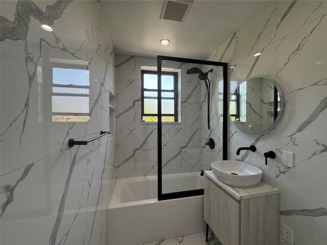 Full bathroom with shower / bathtub combination, vanity, and marble finish floors | Image 9