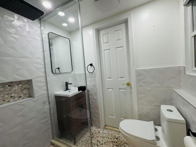 Full bathroom featuring tile walls, vanity, and walk in shower | Image 11