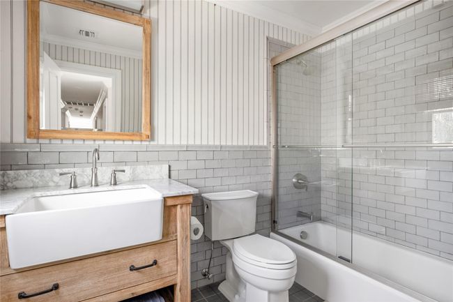 Bathroom featuring shower / bath combination with glass door, visible vents, toilet, vanity, and ornamental molding | Image 39