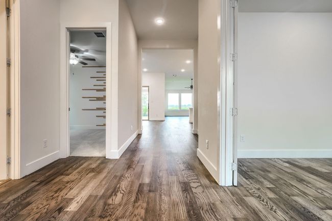 Hall featuring dark wood-type flooring, baseboards, and recessed lighting | Image 4