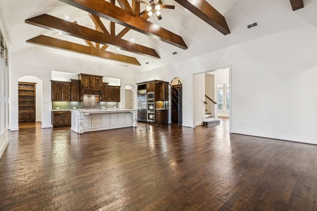 Unfurnished family area with gourmet kitchen view, foyer view, a peek of the library/study room, and stairway to the media room | Image 12