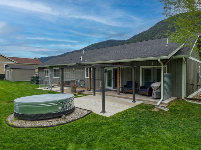 Rear view of property featuring a mountain view, a patio area, roof with shingles, an outdoor structure, and outdoor lounge area | Image 43