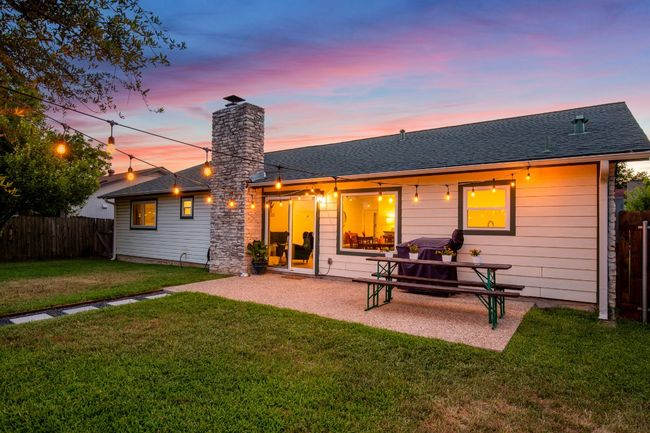 Back of property at dusk featuring a chimney, a patio, and a shingled roof | Image 24